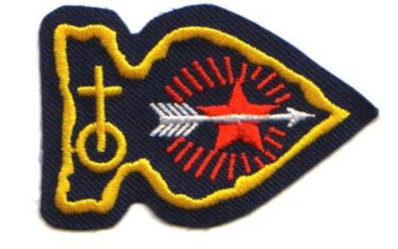 Embroidered patch with arrow and star design.