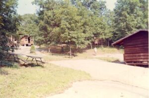 Woodland campground with picnic tables and cabins