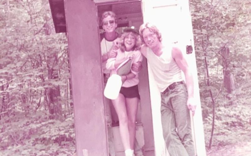 Three people smiling in an outdoor structure.