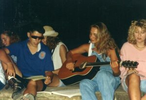 Teenagers singing and playing guitar.