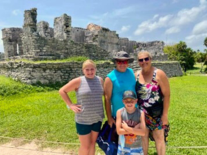 Family posing in front of Mayan ruins.