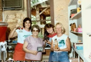Four women smiling in a store.