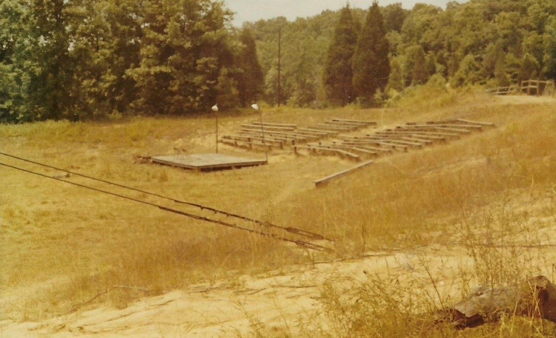 Outdoor amphitheater with wooden stage.