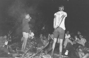 Campfire gathering of teenagers at night.