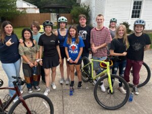 Group of friends with bikes and helmets.