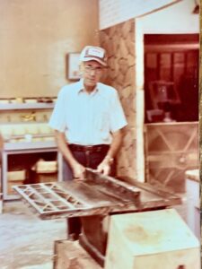A man in a hat using a table saw.