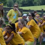 A group of young girls in yellow shirts enjoying a traditional camp experience.