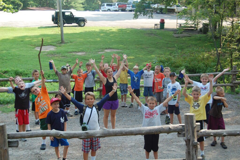 Excited children raising hands at summer camp